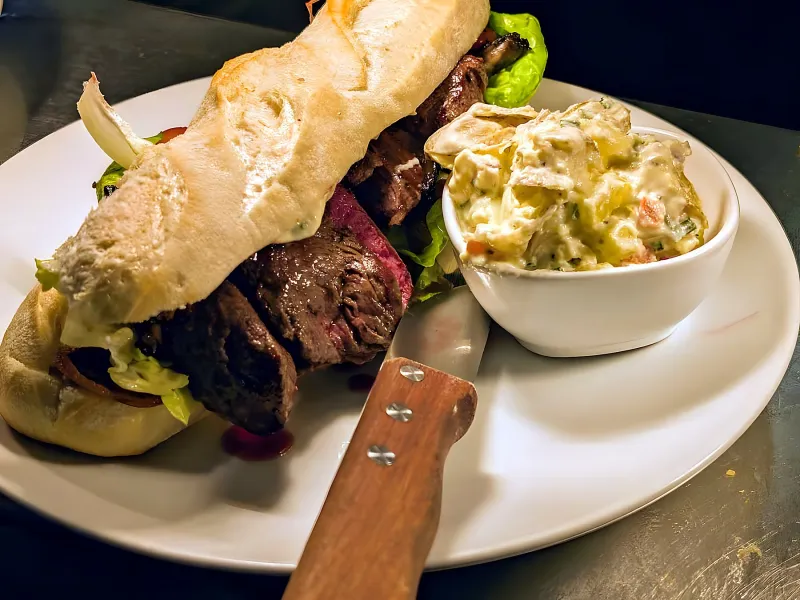Steak sandwich on ciabatta with potato salad